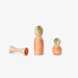 Zwei Spielfiguren aus, die wie Apfelmännchen aussehen und eine Holzapfelputz von Grapat Lucky Lucky 4.