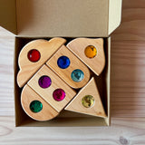 Die Funkeldächer Bausteine von Bauspiel eingeschlichtet in einen Karton. Die Funkelsteine aus Acryl in verschiedenen Farben sind zu sehen.