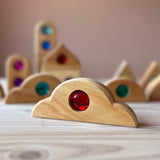 Nahaufnahme eines Funkeldächer Bausteins aus Holz von Bauspiel mit einem roten Acrylstein.