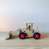 Der Fagus Radlader aus Holz zum Spielen für Kinder ab 3 Jahren seitlich, die Schaufel liegt am Boden auf.