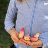 Ein Kind hält die drei Holzspielfiguren "Familie Yay" von Grapat in den Händen.