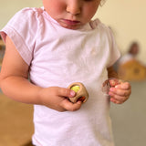 Ein Kind hält einen Glitzerwüfel von Nic Toys in der rechten Hand und einen Funkelstein von Bauspiel in der linken Hand.