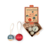 Ein Karton-Schuber, bemalt, leicht geöffnet. Darin und daneben liegen 5 kleine, lasierte und bemalte Holzkugeln in blau und rot Tönen. Jeder Christbaumanhänger hat eine Schlinge.