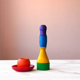 Die rote Holzschlae und der Orange Becher in Kugelform stehen ineinander, daneben sind die restlichen Grapat Pots Becher zu einem Turm gestapelt.