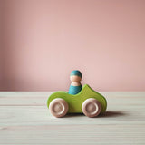 Grimms Holzauto grün mit blauer Spielfigur aus Holz im Spielauto.