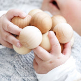 Babyhände halten den Kugel-Greifling natur von Kokomoo.