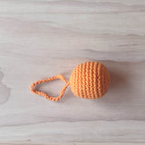Ein oranger Häkelball mit Schlaufe von Kokomoo.