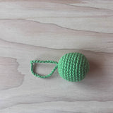Ein grasgrüner Häkelball mit Schlaufe von Kokomoo.