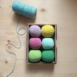 6 Häkelbälle für freies Spiel in sorbet-Farben von Kokomoo in einer Kartonschachtel.
