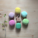 6 Häkelbälle für freies Spiel in sorbet-Farben von Kokomoo aufgelegt im Kreis, in der Mitte die Ostheimer Holzspielfigur Hase sitzend.