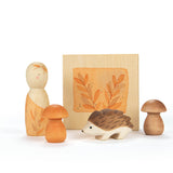Das Spiele- und Forscherset für Kinder "Hello Autumn" von Grapat und Ostheimer stehend vor weißem Hintergrund. Der Holzigel, die beiden Pilze aus Holz, die Nins Spielfigur und die kleine Blätterpresse.