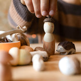 Ein Kind setzt auf die Spielfigur von "Hello Autumn" von Grapat eine Eichelkappe auf, daneben steht die Holzigel Spielfigur.