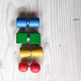 Schrauben und Muttern aus Holz von Nic Toys in den Farben rot, gelb, grün und blau.