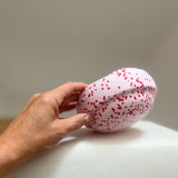 Ein Hand hält den Mini-Stapelstein Blush Christmas-Edition, leicht rosa mit roten Sprenkeln.