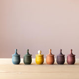 Grapat Wunschbox "Little Things" in allen sechs Farben in einer Reihe aufgestellt. Der gelbe Deckel ist umgedreht, sodass das "Köpfchen" zu sehen ist.