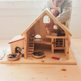 Ein Kind spielt mit dem Holz Bauernhof Kleintierstall von Drei Blätter.