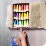 Die Grapat "Sticks" Holzfiguren zum Spielen liegen sortiert nach ihren 18 verschiedenen Farbnuancen in der Kartonverpackung.