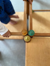 Draufsicht auf 3 Steckhüte aus Holz, bemalt, die in einer Holzkonstruktion stecken