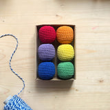 Eine Kartonbox mit 6 Häkelbällen von Kokomoo in rot, orange, gelb, grün, blau und grün.