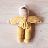 Kuschelpuppe "Sonne" von Grimms mit gelben Pyjama und weißer Haube.