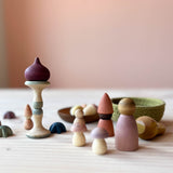 Die 22 verschiedenen Spielmaterialien von Grapat Moonlight Tale stehen und liegen herum, zwei Pilze und ein Zwibel sind zu einem Turm gestapelt.