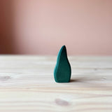Dunkelgrünes, gebüschartiges Holzstück. Ca. 9,5cm hoch, stehend. Das ist das dunkelgrüne Gebüsch von Ostheimer, eine beliebte Holzfigur zum Spielen für Kinder.