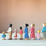 Viele Ostheimer spielfiguren aus Holz in einer Reihe, nach links schauend: Mo der Zwerg, Vater dunkel, Heidi, Sohn, Mutter dunkel, Mutter blond, kleine Tochter, Vater blond.