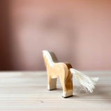 Die Holzfigur zum Spielen für Kinder "Ostheimer hellbrauner Hafllinger" ist zu sehen. Man sieht den Haflinger von hinten, er zeigt seinen Baumwollschweif.