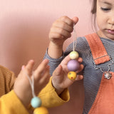 Nahaufnahme eines Kindes, das einen Grapat Snowbuddy Christbaumanhänger in der Hand hält.
