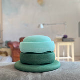 Das Stapelstein Balance Set Greens, gestapelt. Ein dunkelgrünes Stapelstein Balance Board ganz unten, darüber der Stapelstein Original in Dunkelgrün und darüber der Stapelstein Original in Mint.