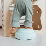 Ein Kleinkind steht mit einem Bein auf einem Stapelstein Original in Mint.