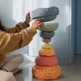 Ein Turm von 8 unterschiedlich großen Stapelsteinen in Pastellfarben - die beiden größten Stapelsteine sind gesprenkelt in Blau- bzw GelbRot-Tönen