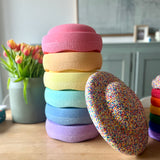 Das Stapelstein® Set classic in Pastell Farben mit Confetti Balance Board. Im Hintergrund eine Vase mit Tulpen.