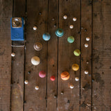 Die Planeten von Dear Universe im Kreis als Sonnensystem aufgelegt, daneben die Monde und Sterne, sowie eine Taschenlampe.