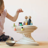 Ein Turm gebaut aus den blätterförmigen Holzplatten "Petal Platforms" von Grapat. Darauf stehen verteilt auf verschiedenen Ebenen kleine Spielfiguren aus Holz.