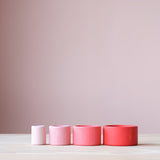 Die vier roten Grapat "Nest Bowls" Holzbecher in den vier Farbabstufungen und Größen nebeneinander aufgestellt.