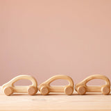 Drei Holzautos zum Greifen lernen und spielen für Babys von Kokomoo hintereinander.