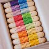 Die Grapat Brots Spielfiguren aus Holz nach ihren bunten Farben sortiert in ihrer Karton Verpackung.