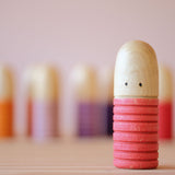 Eine Grapat Bots Spielfigur in rot von ganz nah fotografiert, sodass die Maserung des Holzes gut zu sehen ist.