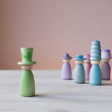 Die grüne Spielfigur mit farblich passendem grünen Hut vorne, hinten stehen Grapat Fancy Nins in Blau- und Lilatönen.