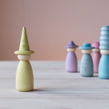 Die gelbe Spielfigur mit farblich passendem gelben Hut vorne, hinten stehen Grapat Fancy Nins in Blau- und Lilatönen.