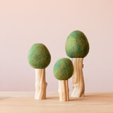 Die Filzbäume Sommer mit grüner Baumkrone aus Filz und einem Stamm aus Treibholz in den drei verschiedenen Größen 23cm, 16cm und 28cm nebeneinander.