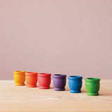 Grapat "Mates" Töpfchen aus Holz in 6 Regenbogen Farben stehen in einer Reihe.