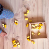 In und um die kleine Holzbox von Grapat liegen gelbe Mandalasteine "Blüten" verteilt.