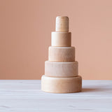 Die fünf Holzbecher des Grimms Schälchenset zum einem Stapelturm aufgebaut.