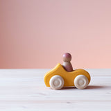 Grimms Holzauto gelb mit Spielfigur aus Holz im Spielauto.