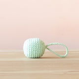 Ein mintfarbener Häkelball mit Schlaufe von Kokomoo.