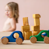 Grimms erstes Holzauto in blau für Babies mit großem Griffloch, dahinter das grüne.