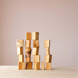 Naturbelassene Wald-Holzbau-Klötze mit Rinde sind als Türme nebeneinander aufgestapelt.