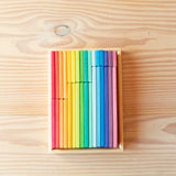 Flache, bunte Holzbausteine in einer Schachtel aus Holz, sortiert nach den vielen Farben des Regenbogens, in 5 verschiedenen Größen.